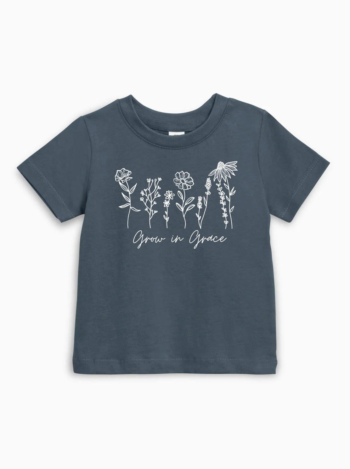 Kids organic cotton T-shirt in dark blue with white wildflower graphic and Grow in Grace text.
