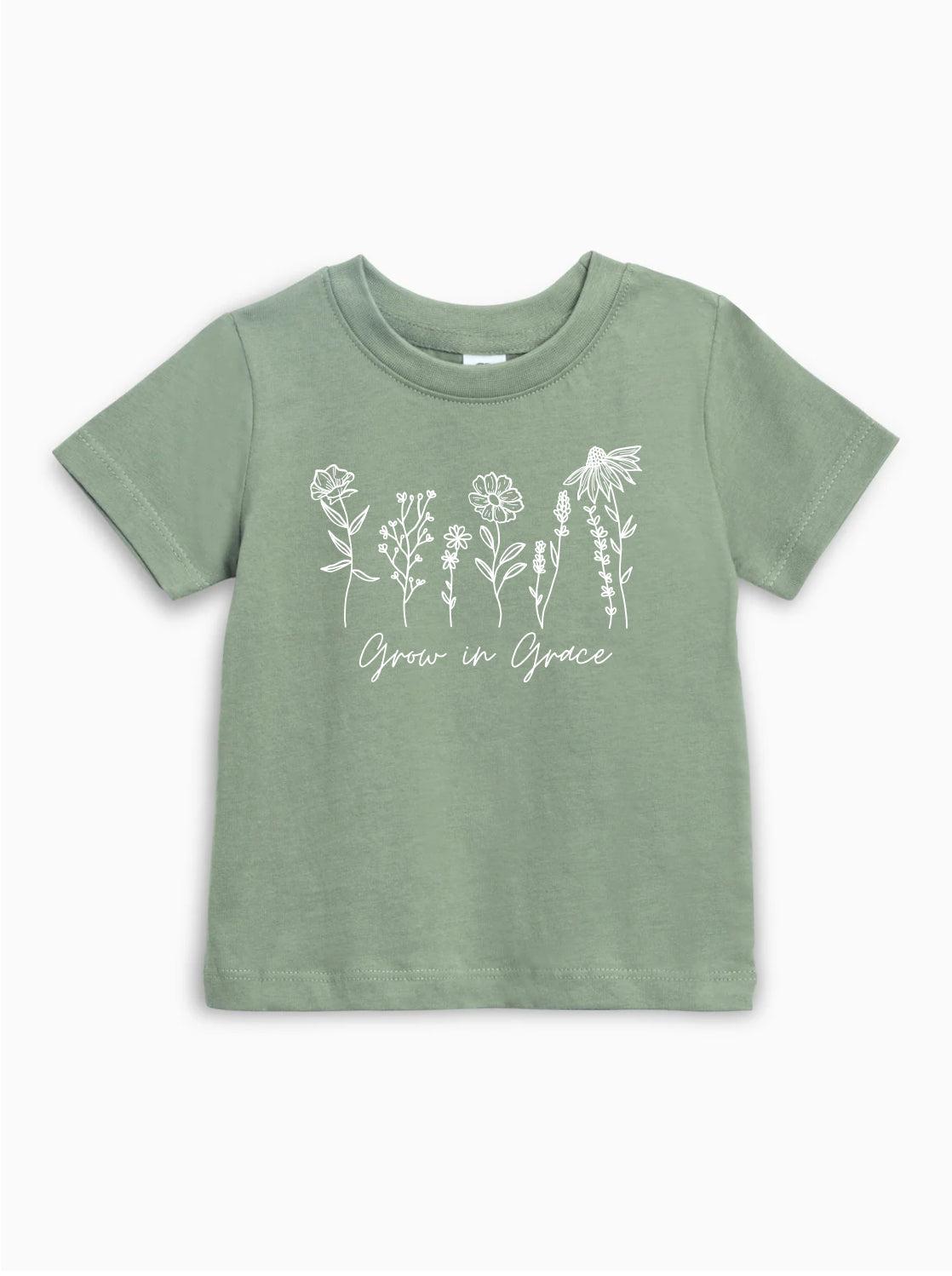Kids organic cotton T-shirt in thyme green with white wildflower graphic and Grow in Grace text.