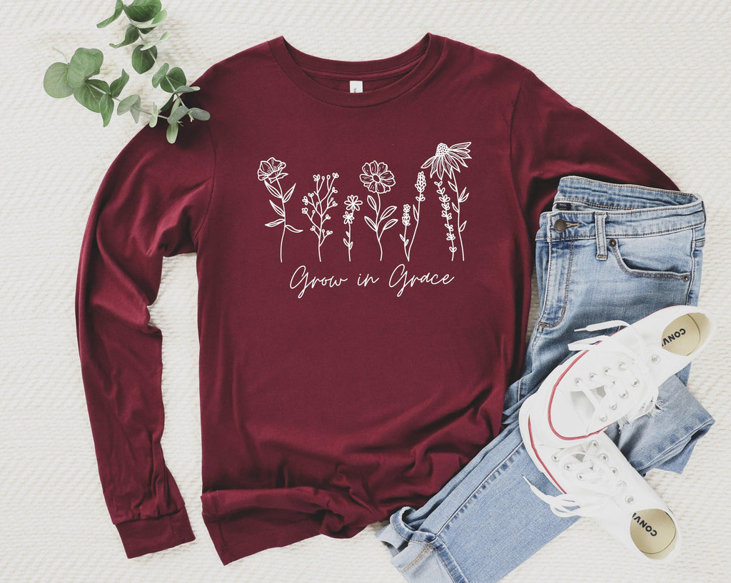 Maroon long sleeve T-shirt with white botanical “Grow in Grace” graphic