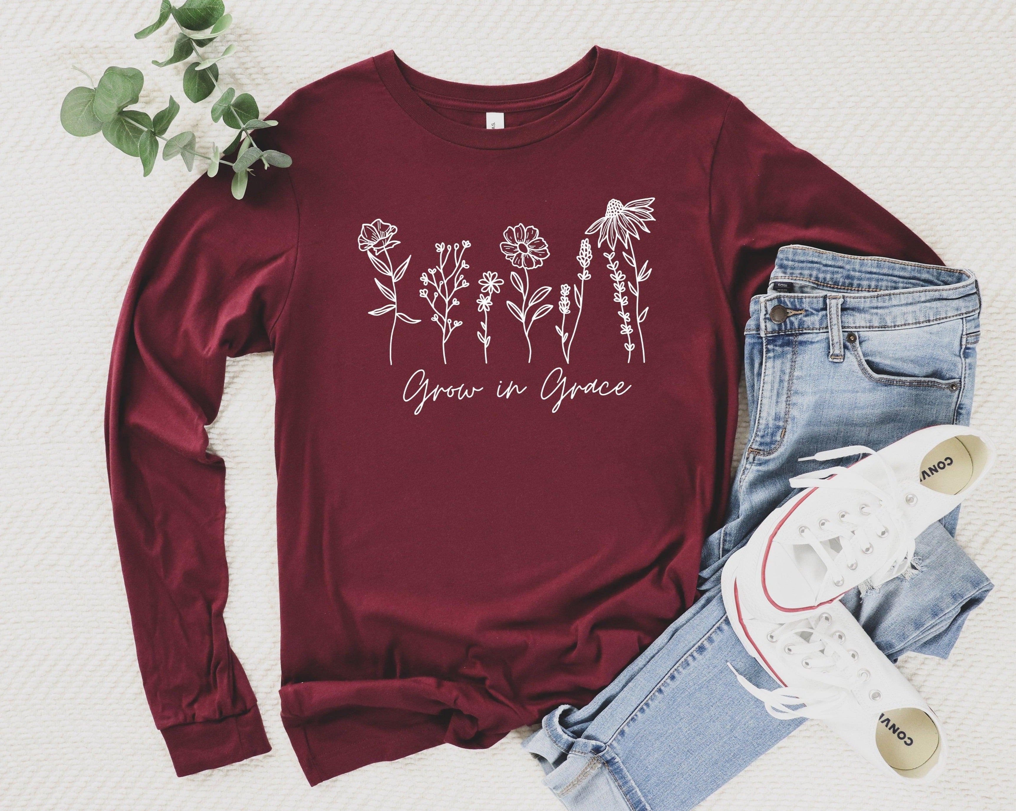 Maroon long sleeve T-shirt with white botanical “Grow in Grace” graphic