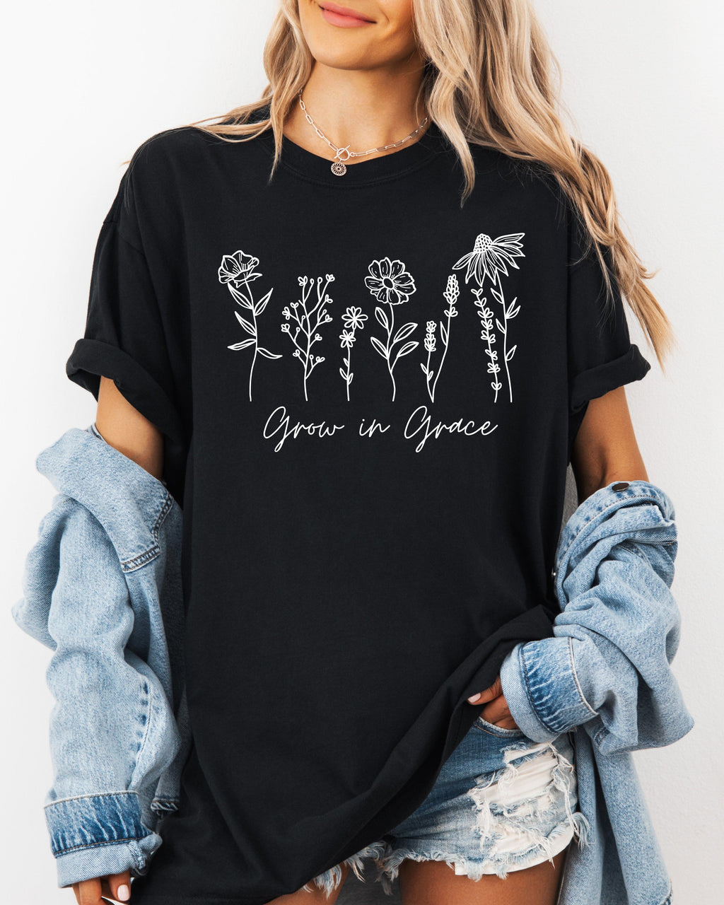 Black unisex graphic t-shirt with floral “Grow in Grace” print across chest