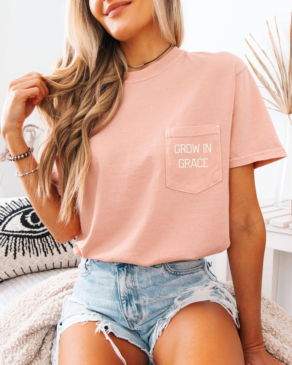 Women's peach pocket T-shirt with 'Grow in Grace' text in front pocket