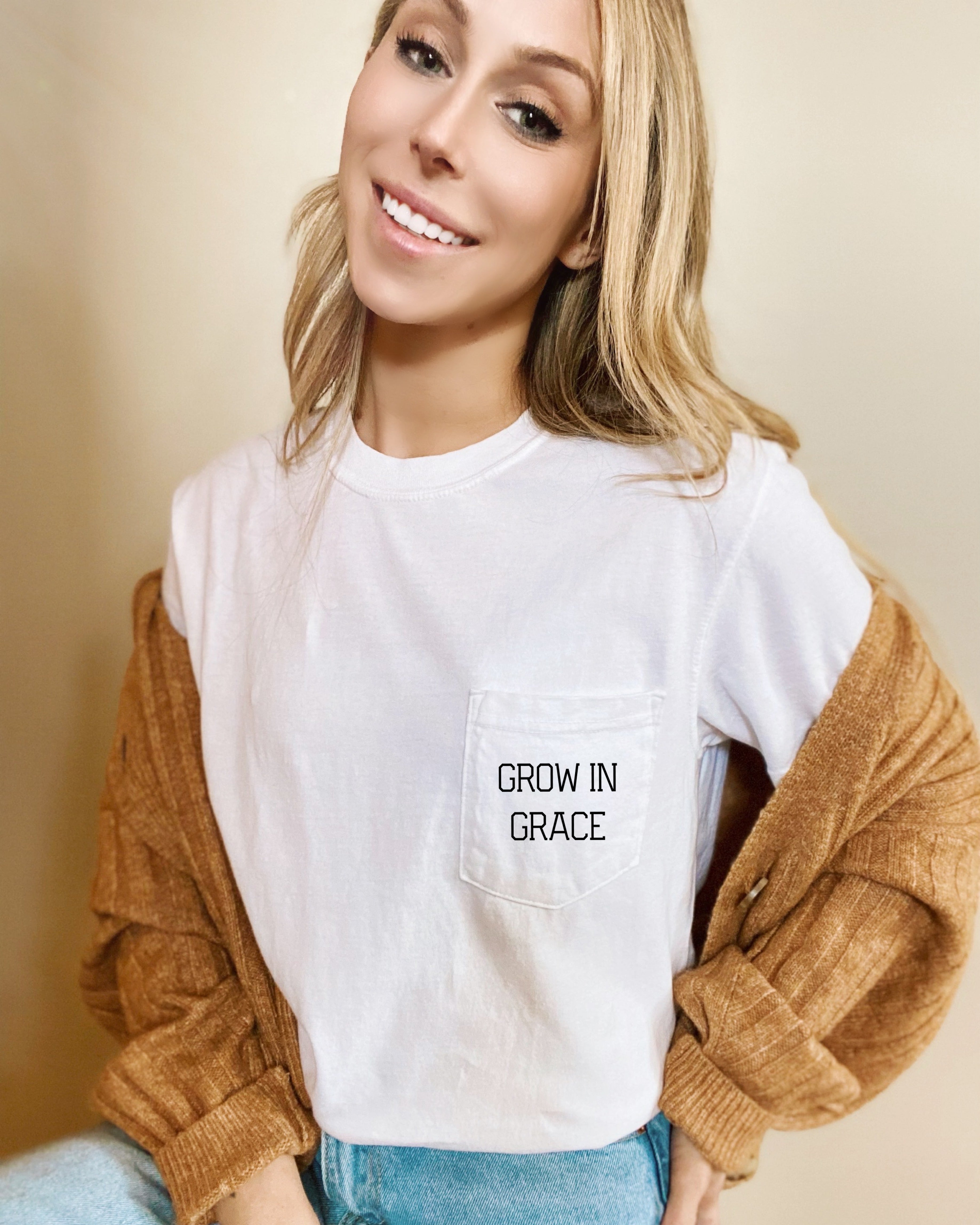 Women's white pocket T-shirt with 'Grow in Grace' text graphic