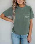Women's moss green pocket T-shirt with 'Grow in Grace' text graphic
