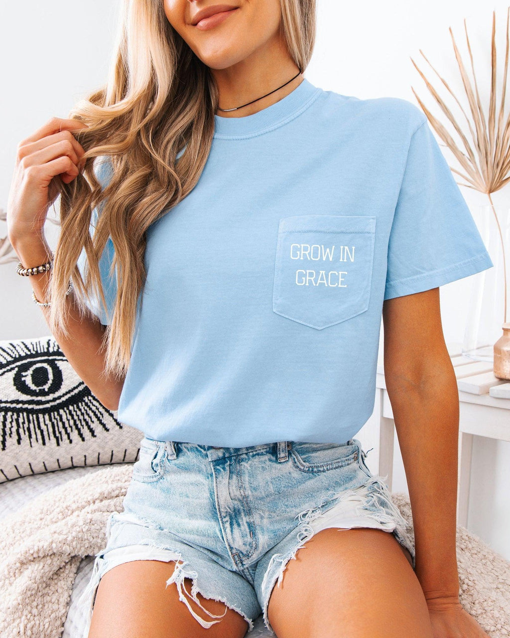Women's light blue pocket T-shirt with 'Grow in Grace' text graphic