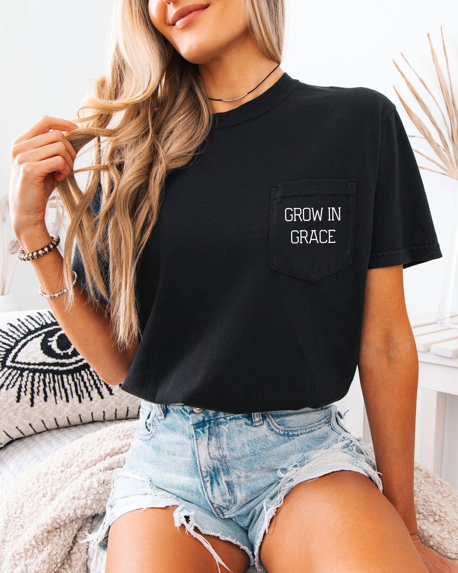 Women's black pocket T-shirt with 'Grow in Grace' text graphic