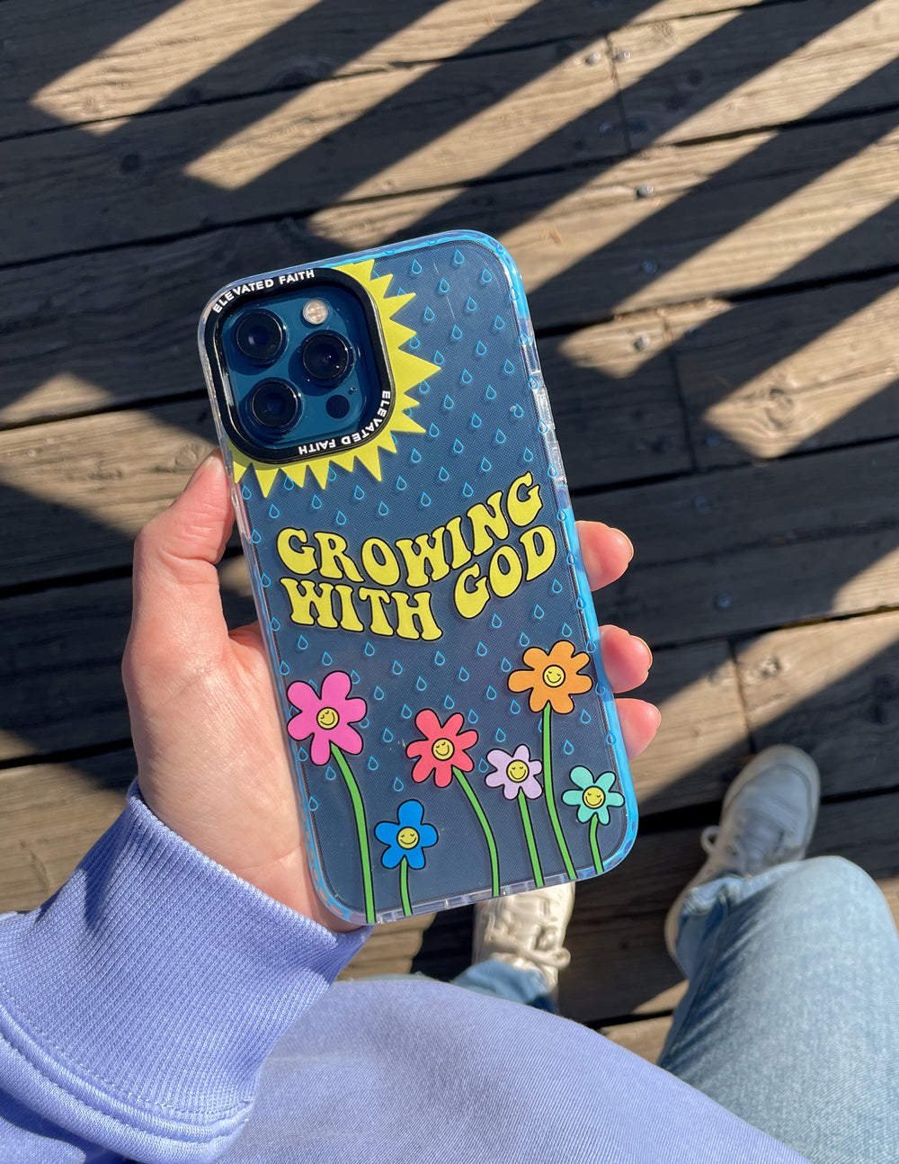 Blue phone case with 'Growing With God' and garden flower graphics