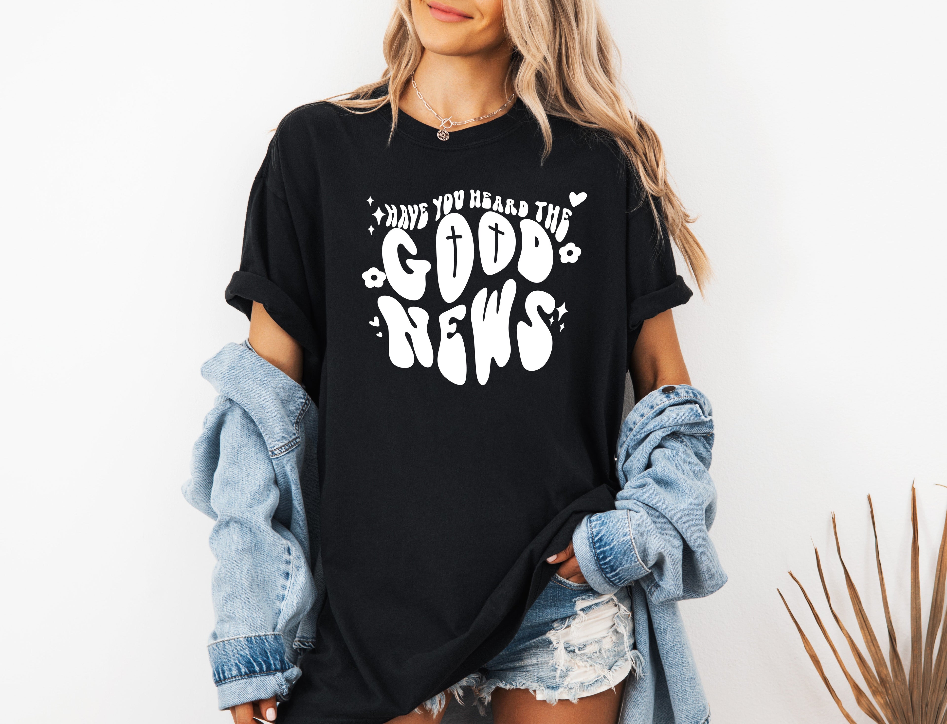 Black garment-dyed Christian T-shirt with white cross and “Good News” front graphic