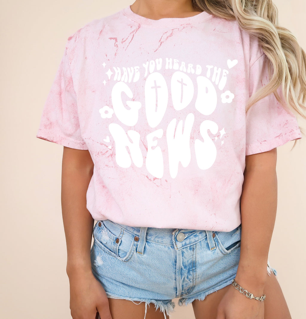 Blush pink garment-dyed Christian T-shirt with white cross and “Good News” front graphic