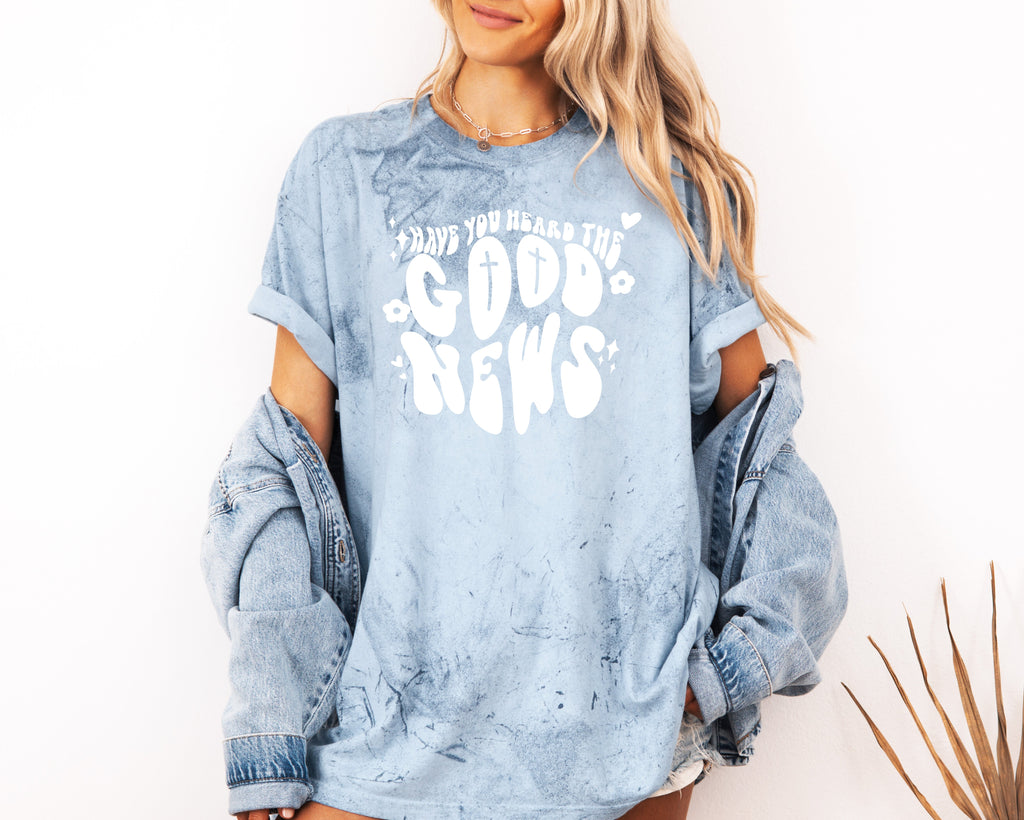 Light blue garment-dyed Christian T-shirt with white cross and “Good News” front graphic