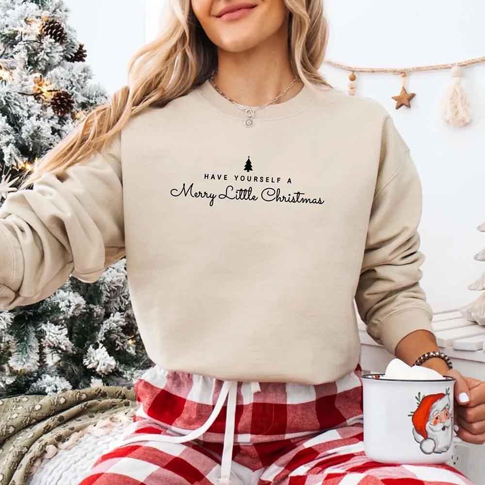 Beige crewneck sweatshirt on model with holiday tree and cursive text