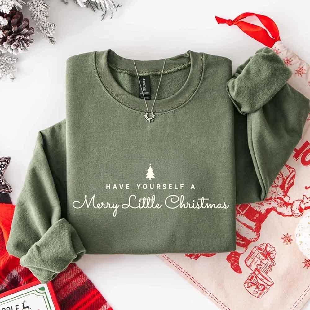 Olive green crew-neck sweatshirt with Merry Little Christmas text and tree graphic