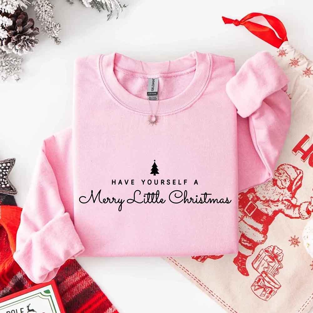 Light pink crew-neck sweatshirt with Merry Little Christmas text and tree graphic