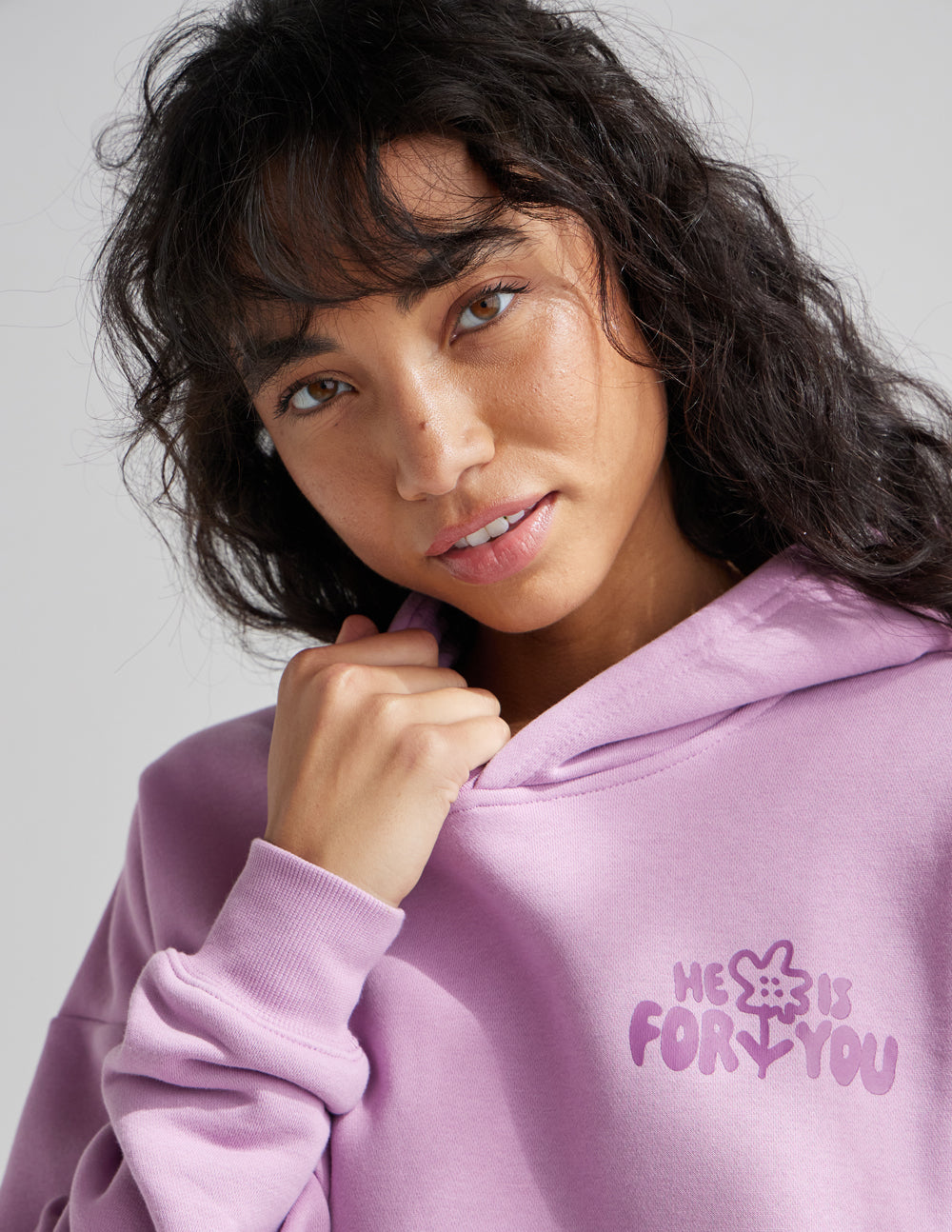 Unisex lilac hoodie close-up with hood and small front graphic