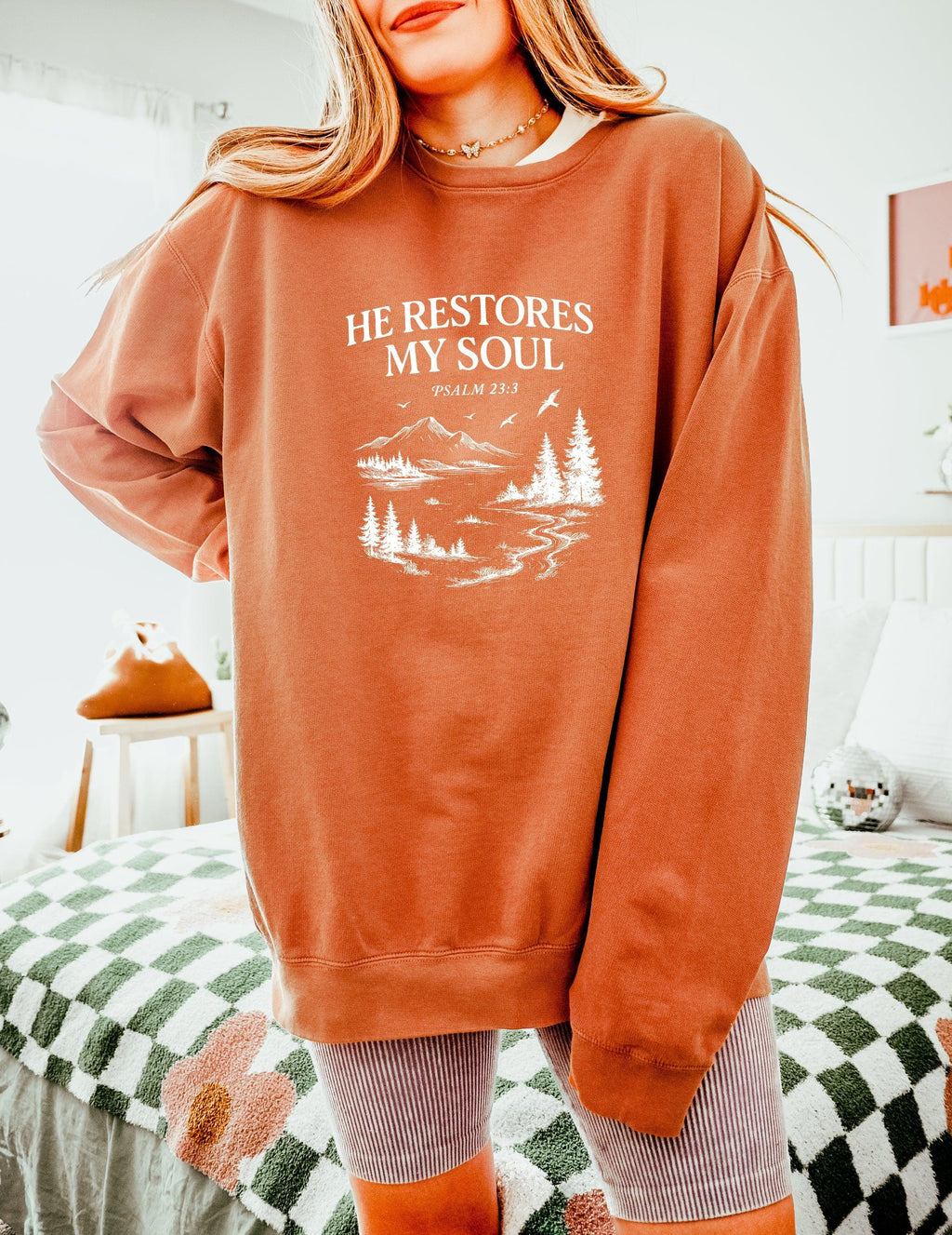 Dyed peachy sweatshirt with “He Restores My Soul” Psalm 23:3 forest graphic