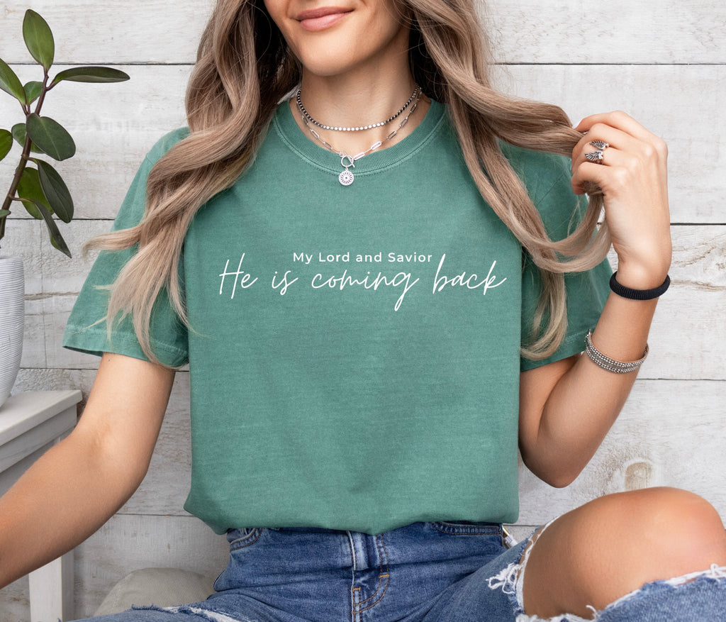 Green T-shirt with “He is coming back” script text on the chest