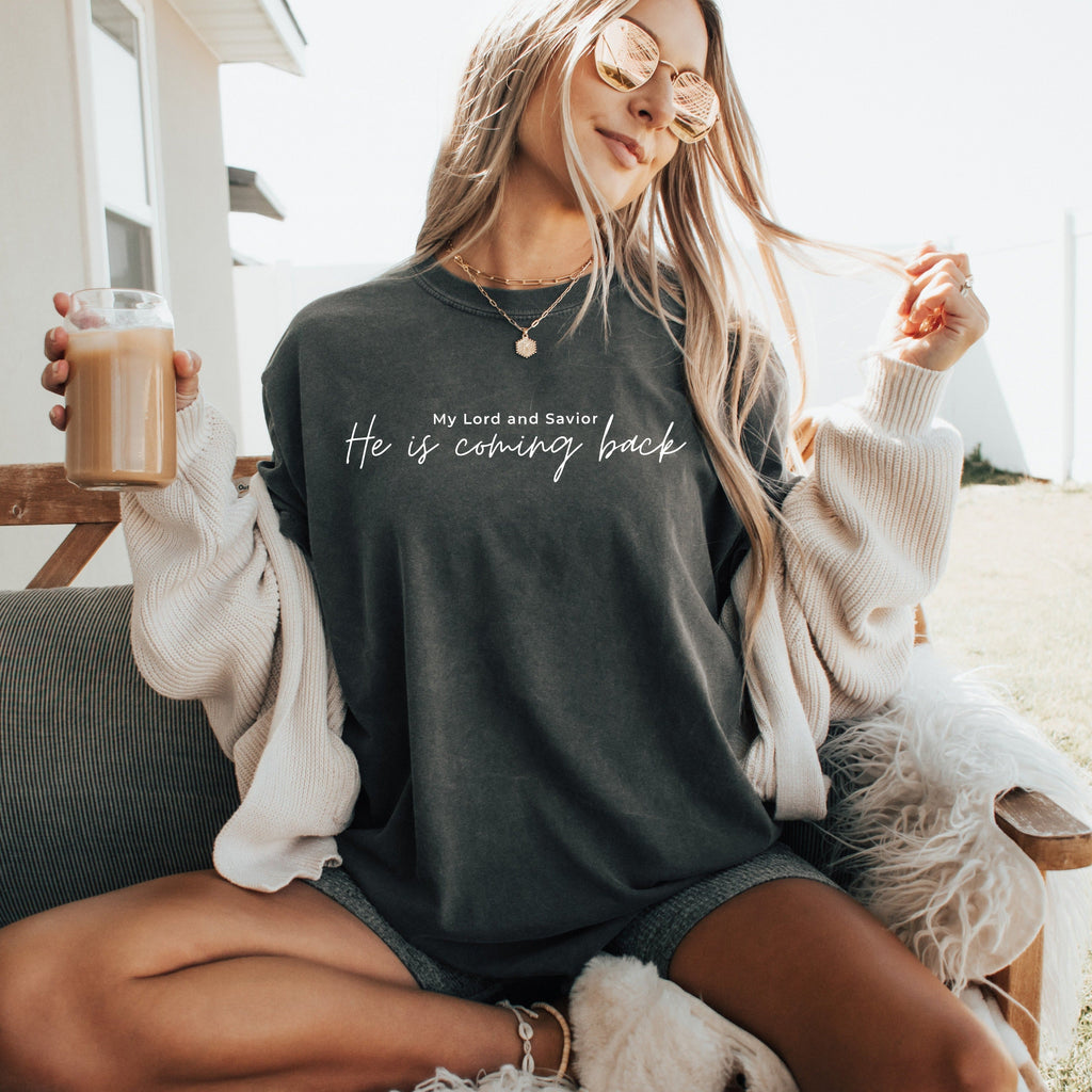 Women's dark gray graphic T-shirt with “He is coming back” text in center