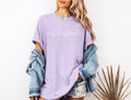 Lavender T-shirt with script graphic and small text printed across the front