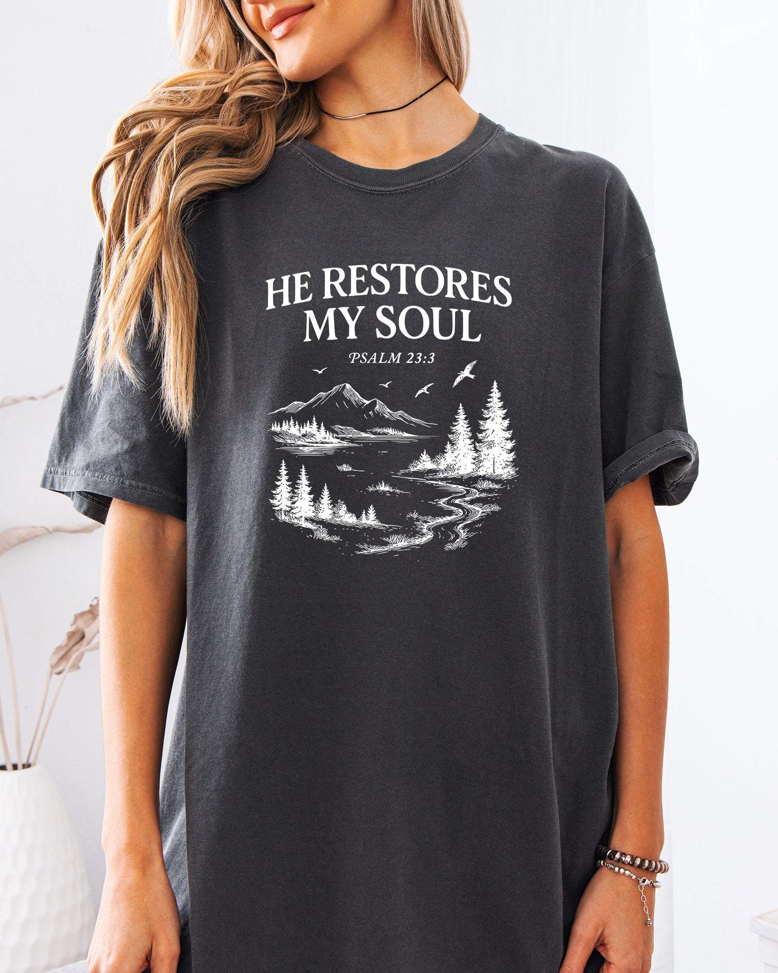 Dark gray unisex T-shirt with white “He Restores My Soul” mountain graphic, crew neck