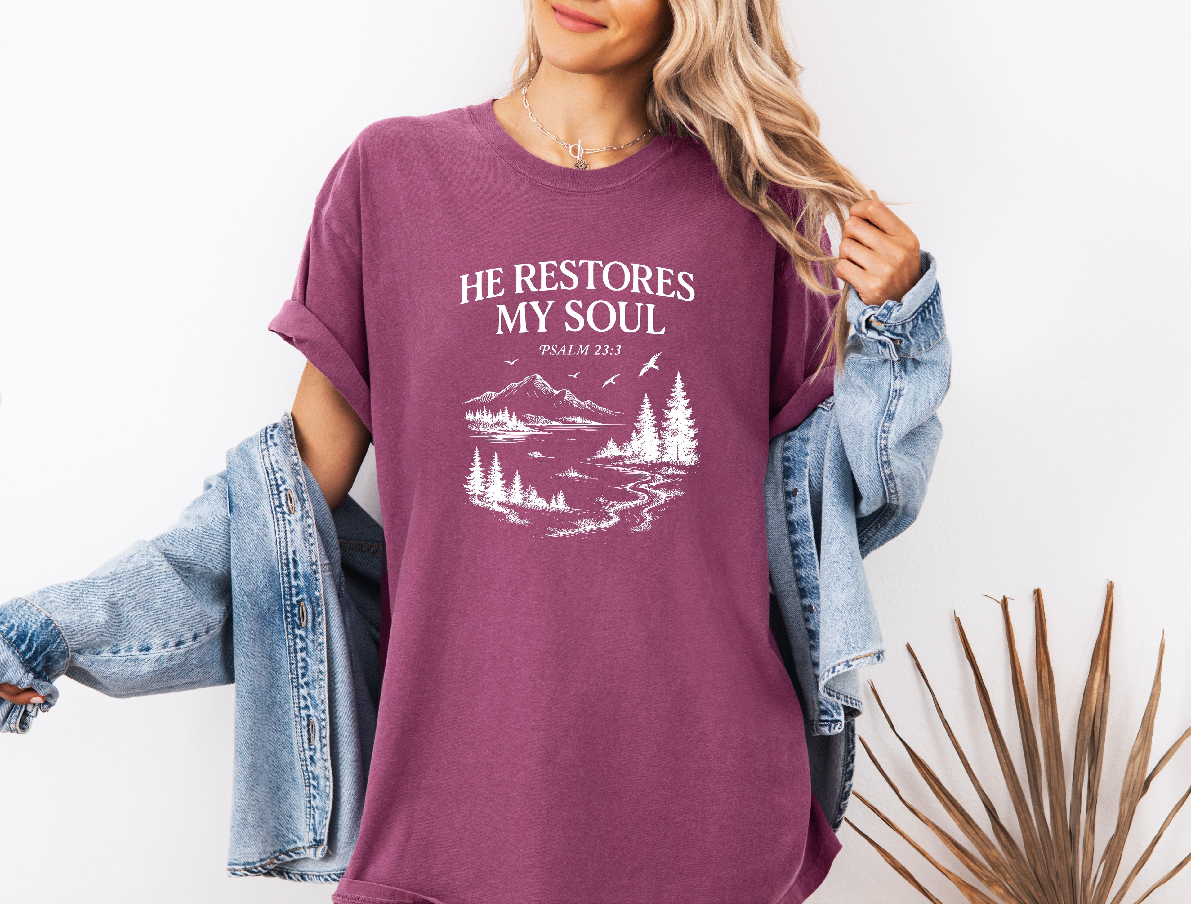 Purple unisex T-shirt with white “He Restores My Soul” mountain and tree graphic, crew neck
