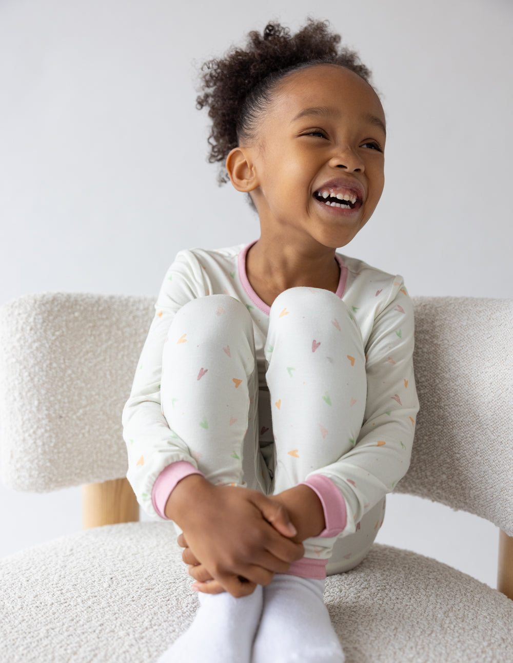 Kids pajama set in light cream with heart print; crew neck with pink trim and cuffs