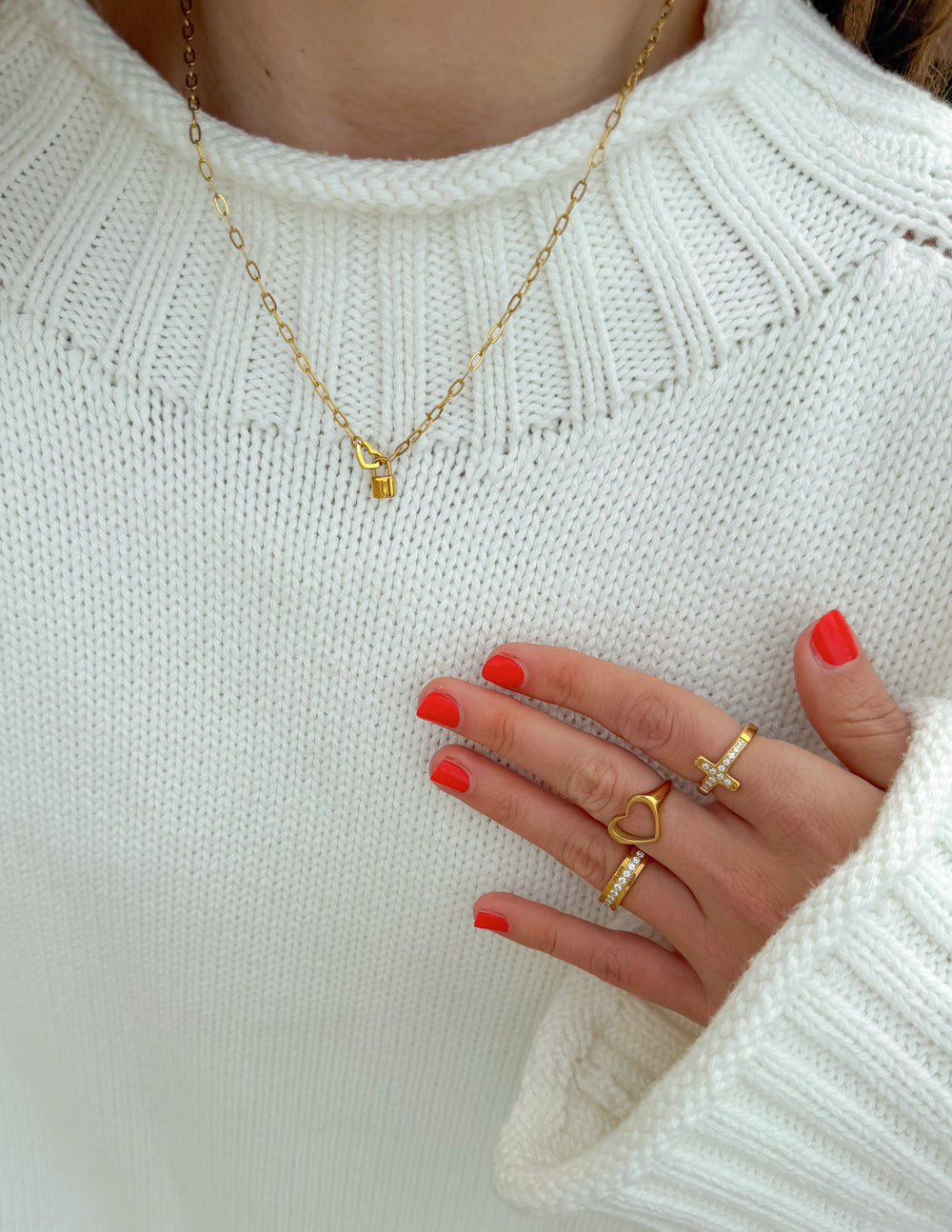Gold paperclip chain necklace on sweater neckline, heart lock pendant