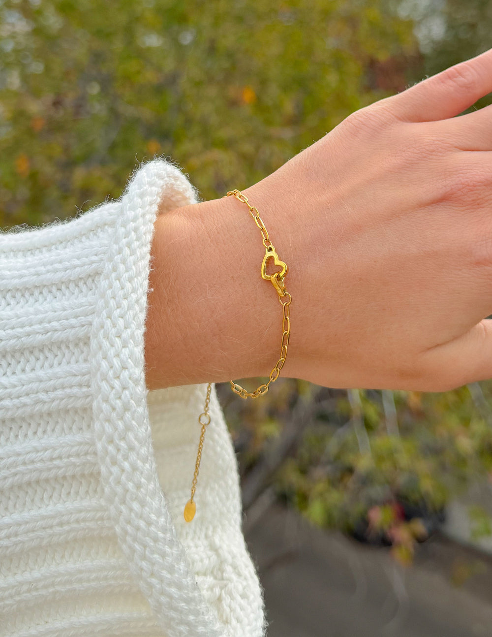 Gold heart charm paperclip chain bracelet on wrist