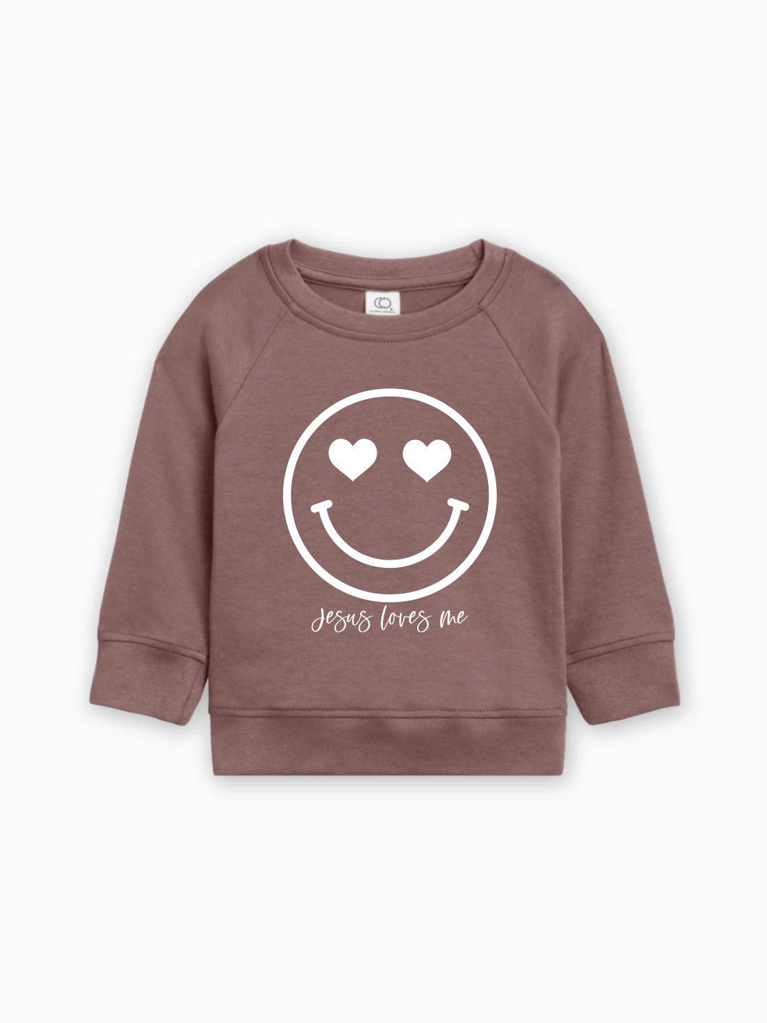 Mauve kids organic cotton pullover with white heart smiley graphic and 'Jesus loves me'