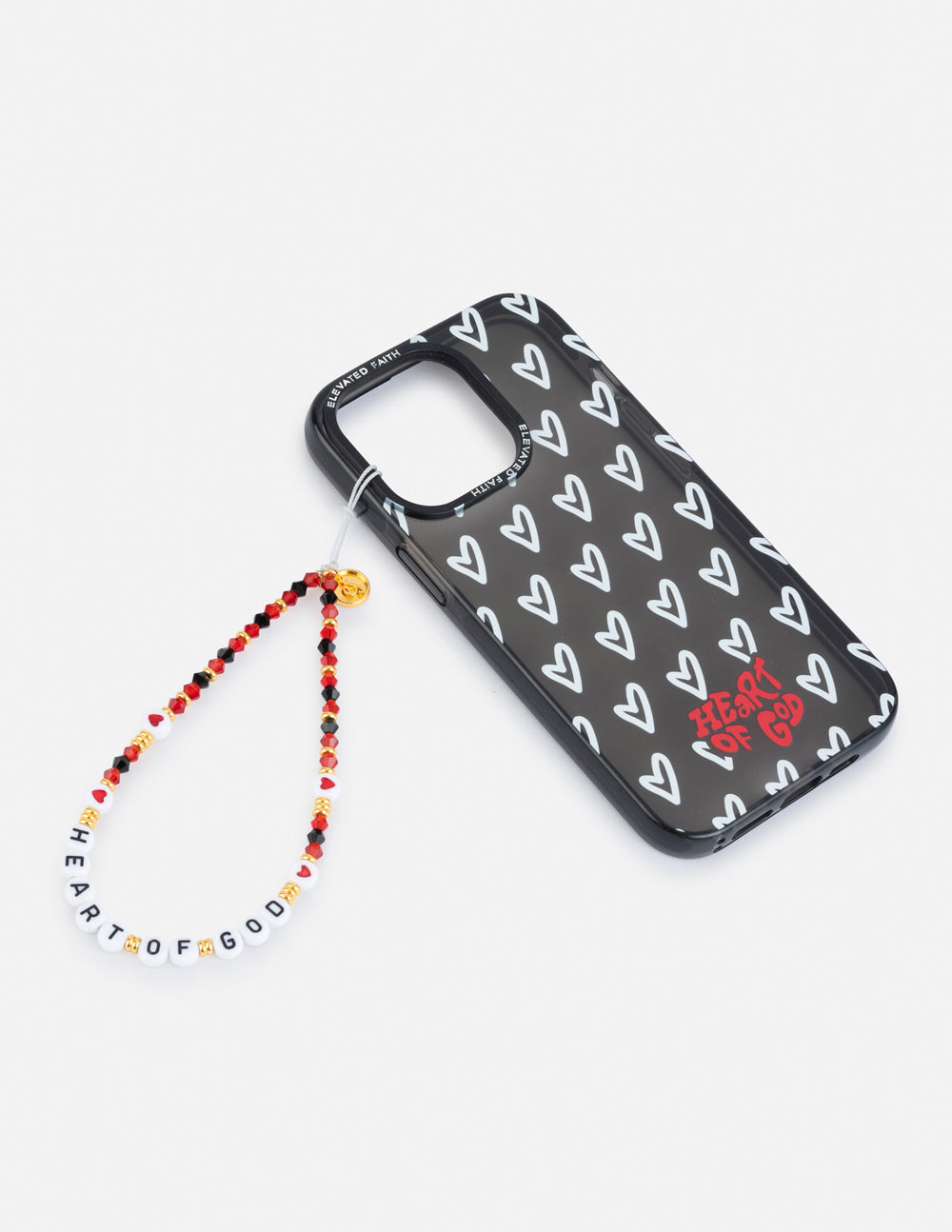 Beaded phone charm beside black phone case with white heart pattern