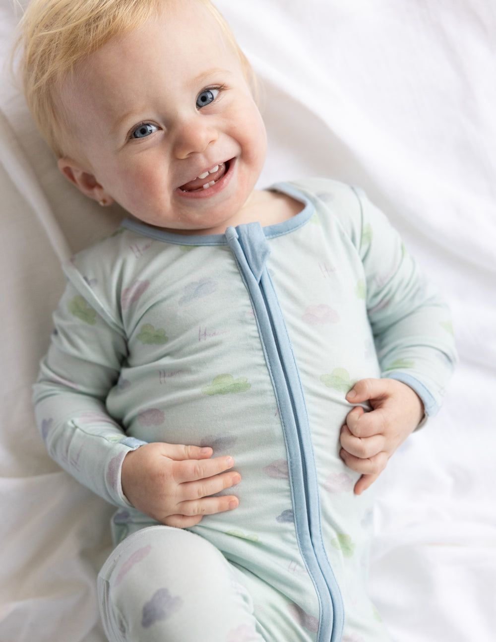Light blue baby footed onesie with pastel icon print and front zipper