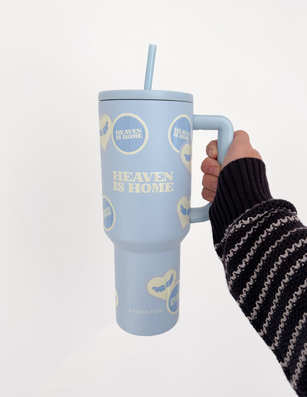 Light blue 40 oz tumbler with straw and handle, gripped by a hand