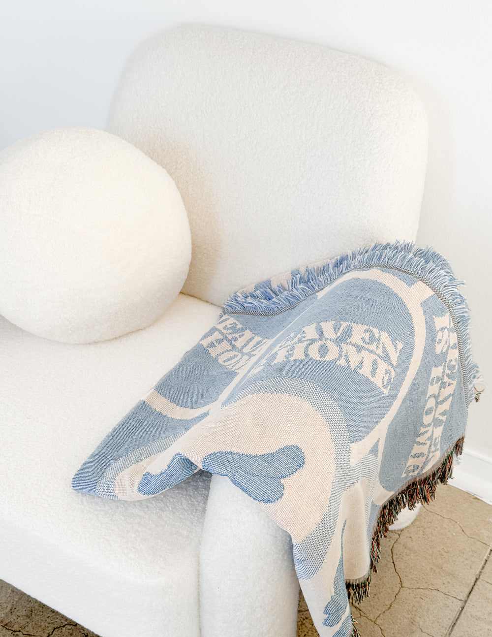 Light blue heart and text throw blanket with fringed edge, draped on chair