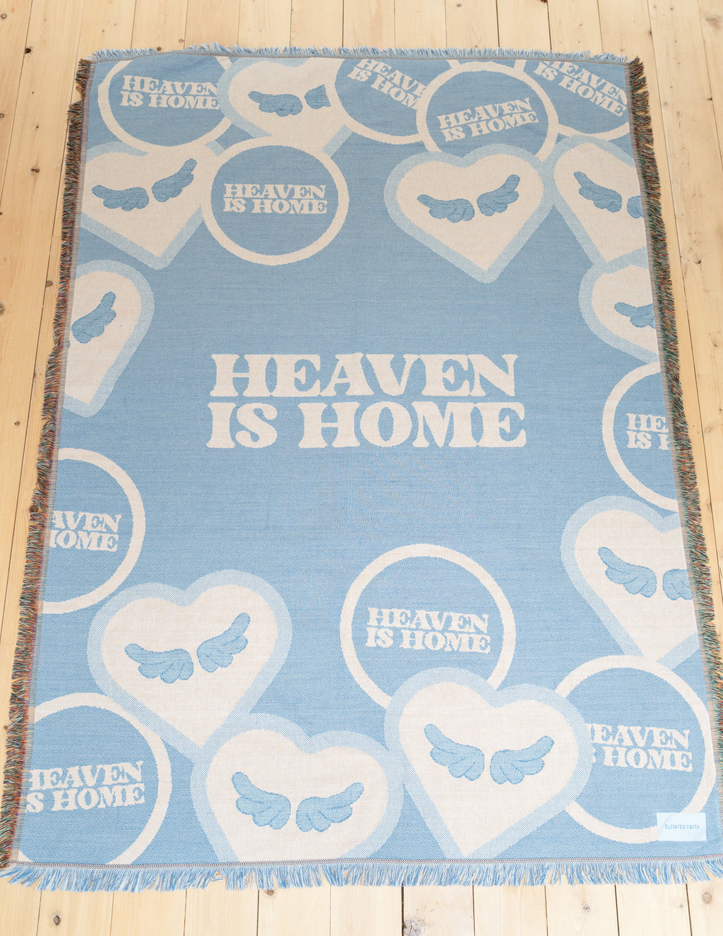 Light blue heart-pattern throw blanket with 'Heaven is Home' text and fringed border
