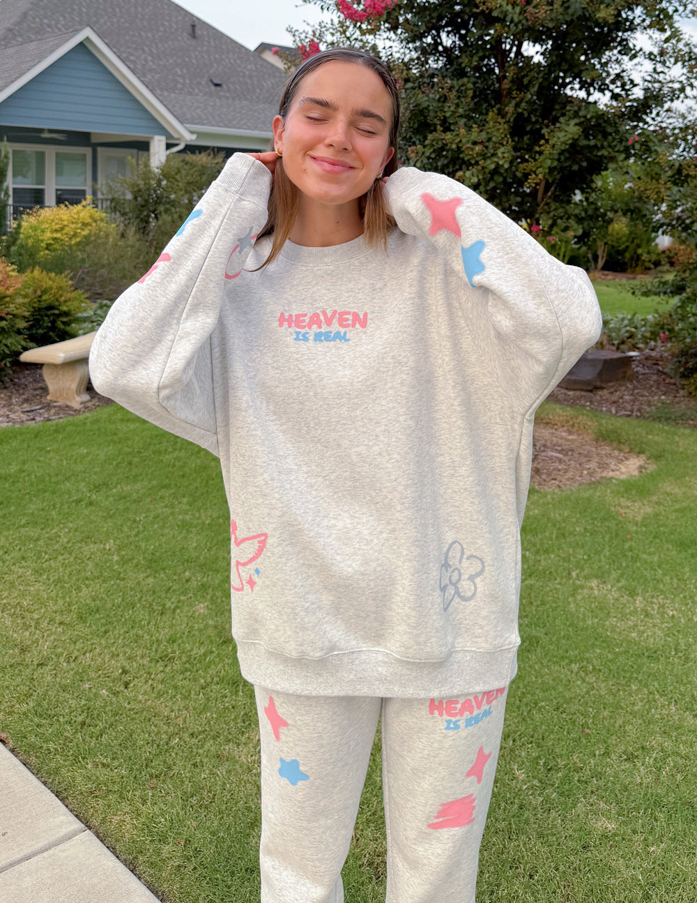 Unisex crewneck sweatshirt set in heather gray with colorful prints, front view outdoors
