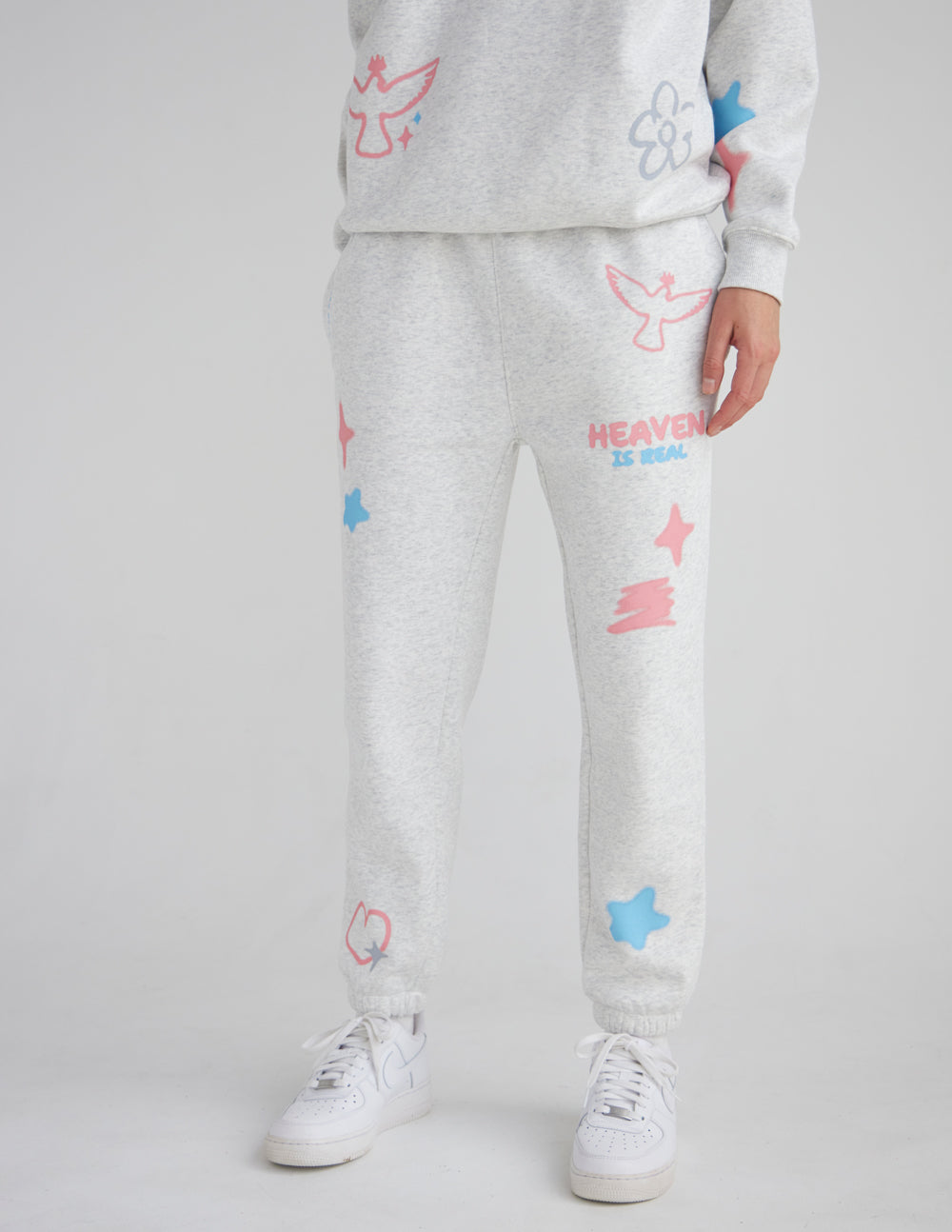 Light gray unisex sweatpants with jogger cuffs and pastel star and heart prints, front logo