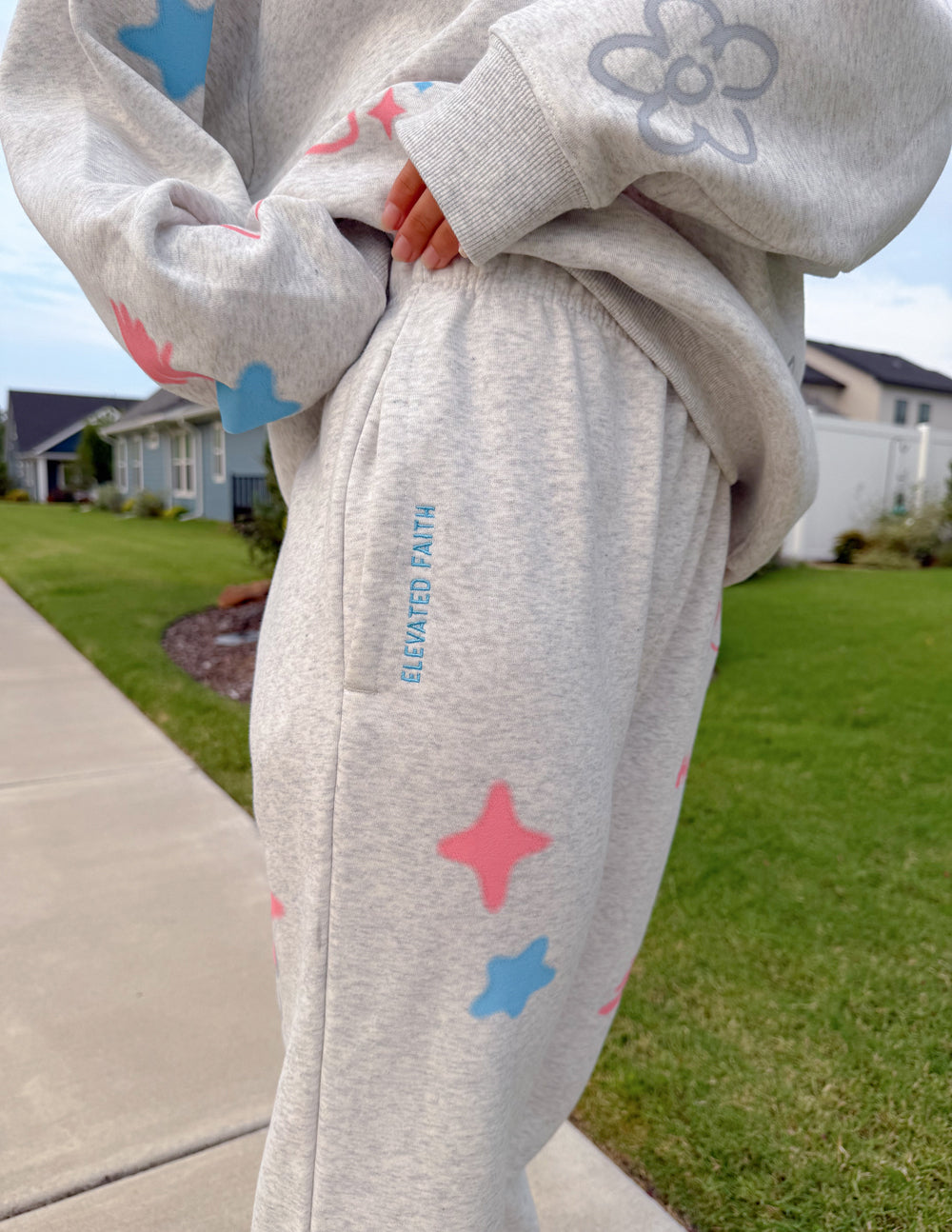 Light gray unisex sweatpants with elastic waist and pastel star and bunny prints, side detail