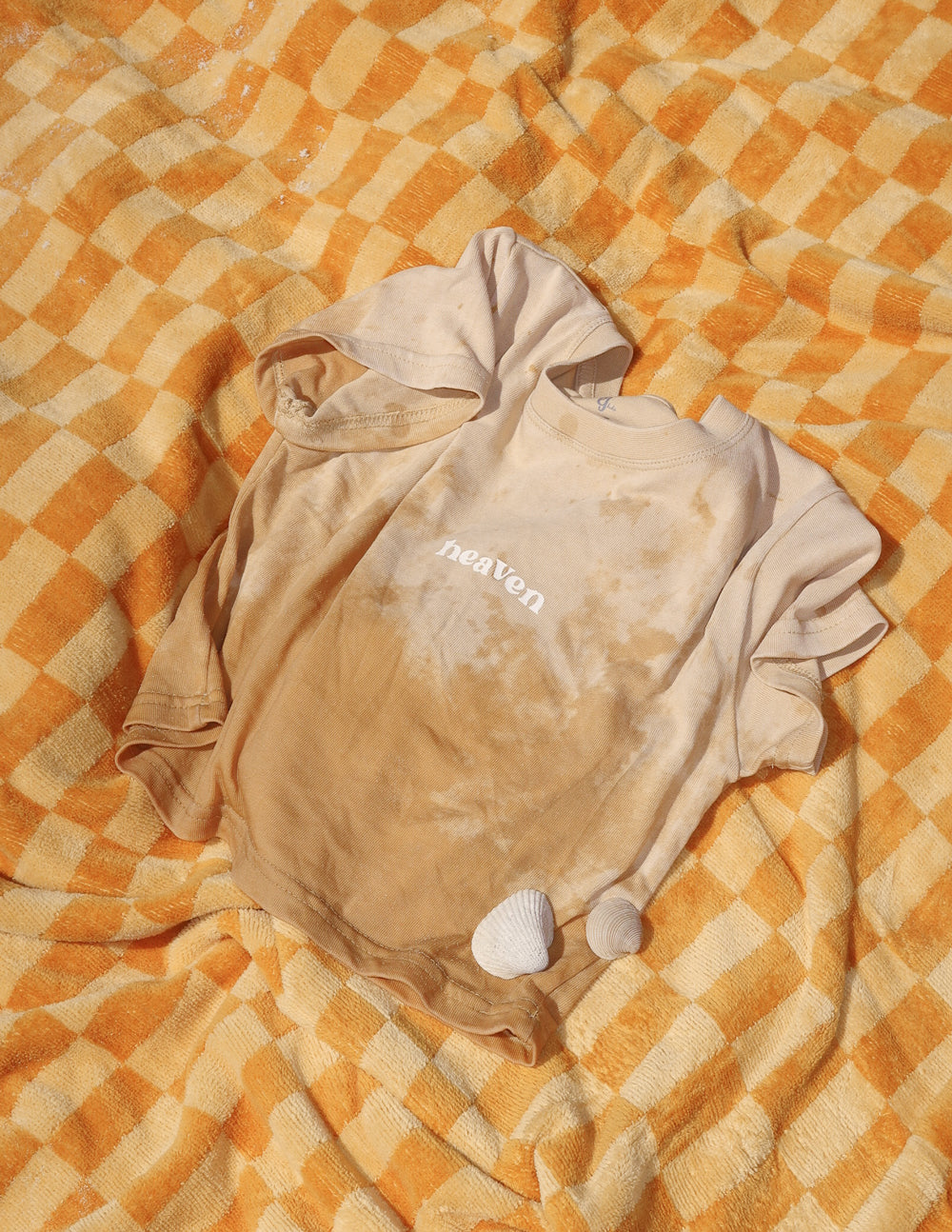 Folded kids tan T-shirt with 'heaven' logo print on the front, crew neck, short sleeves