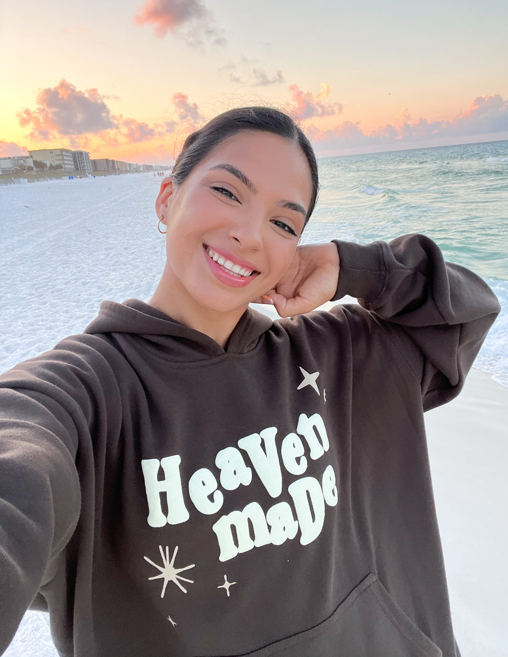 Unisex hoodie in dark brown with “Heaven Made” graphic on the front pocket area.