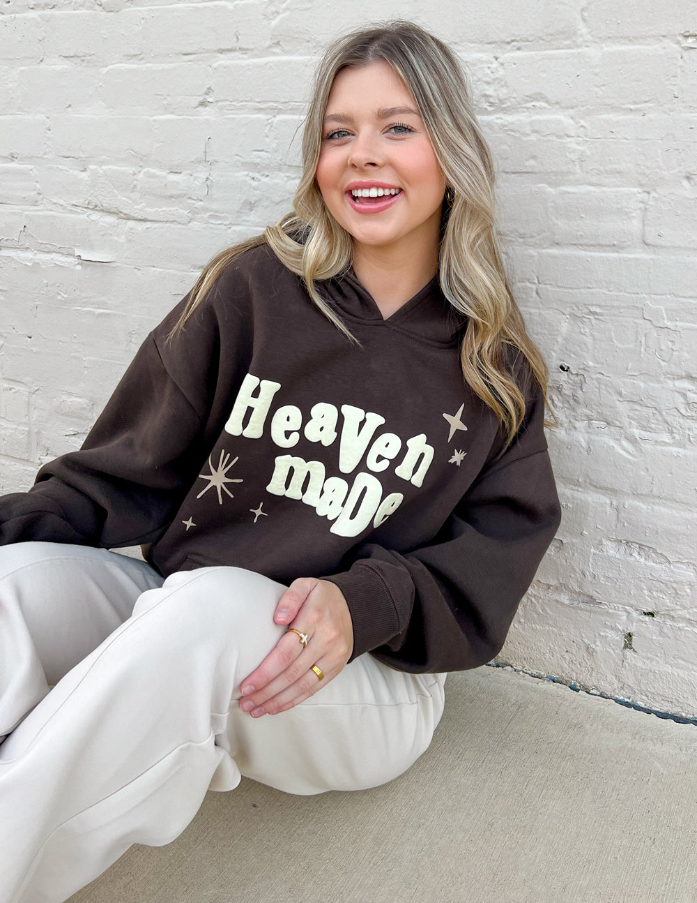 Dark brown unisex hoodie with hood and “Heaven Made” graphic across the front.