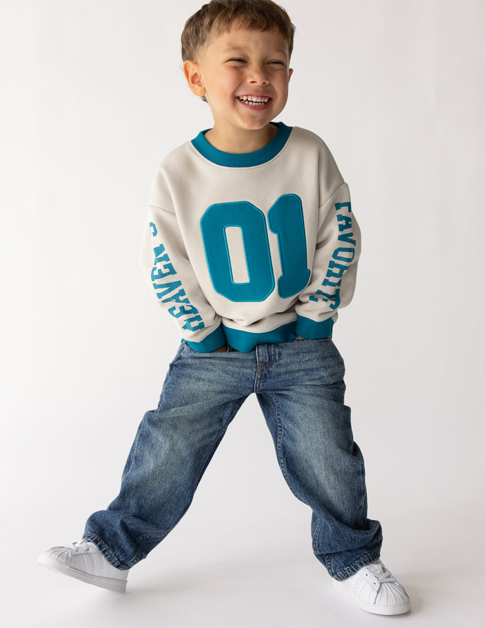 Kids crewneck sweatshirt in cream with large teal 01 front graphic and teal cuffs