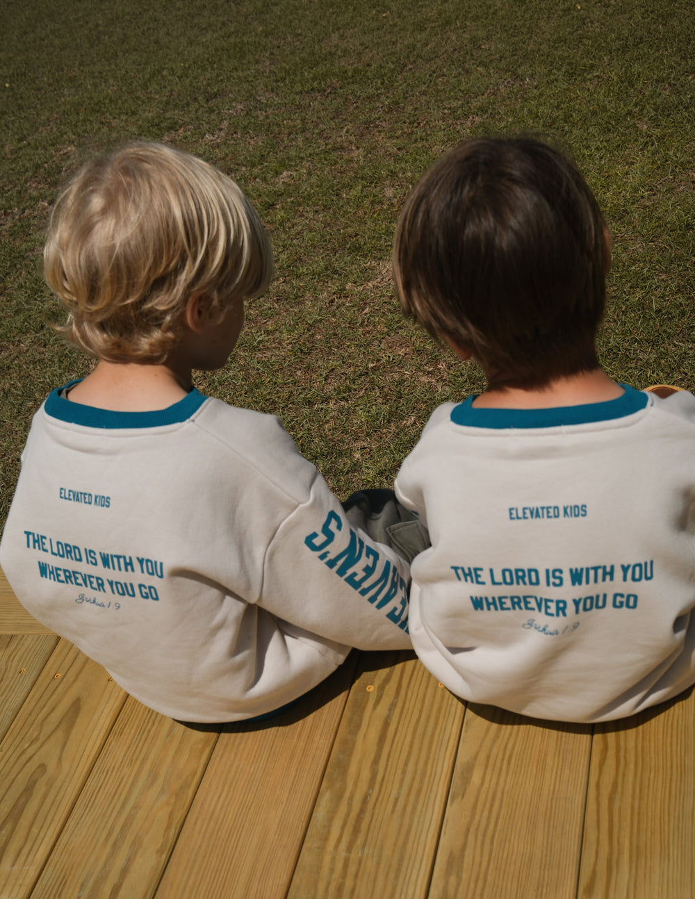 Kids crewneck sweatshirt back view, cream with teal collar and motivational text