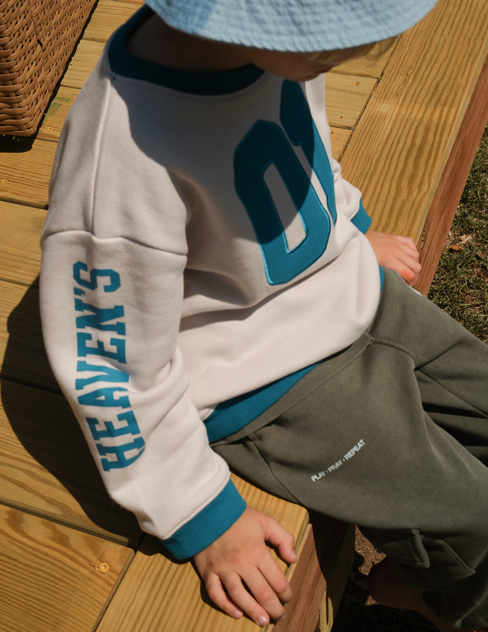 Kids crewneck sweatshirt in cream with teal number 01 and vertical sleeve text