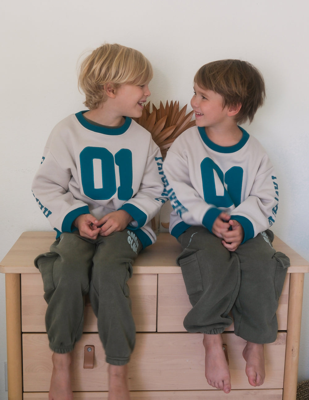 Kids crewneck sweatshirt in cream with teal number 01 front and ribbed teal cuffs