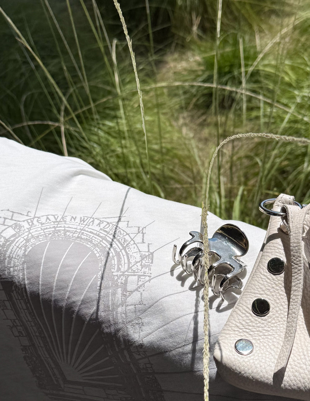 Close-up of white tee fabric with arched graphic print detail and thick graphic lines.