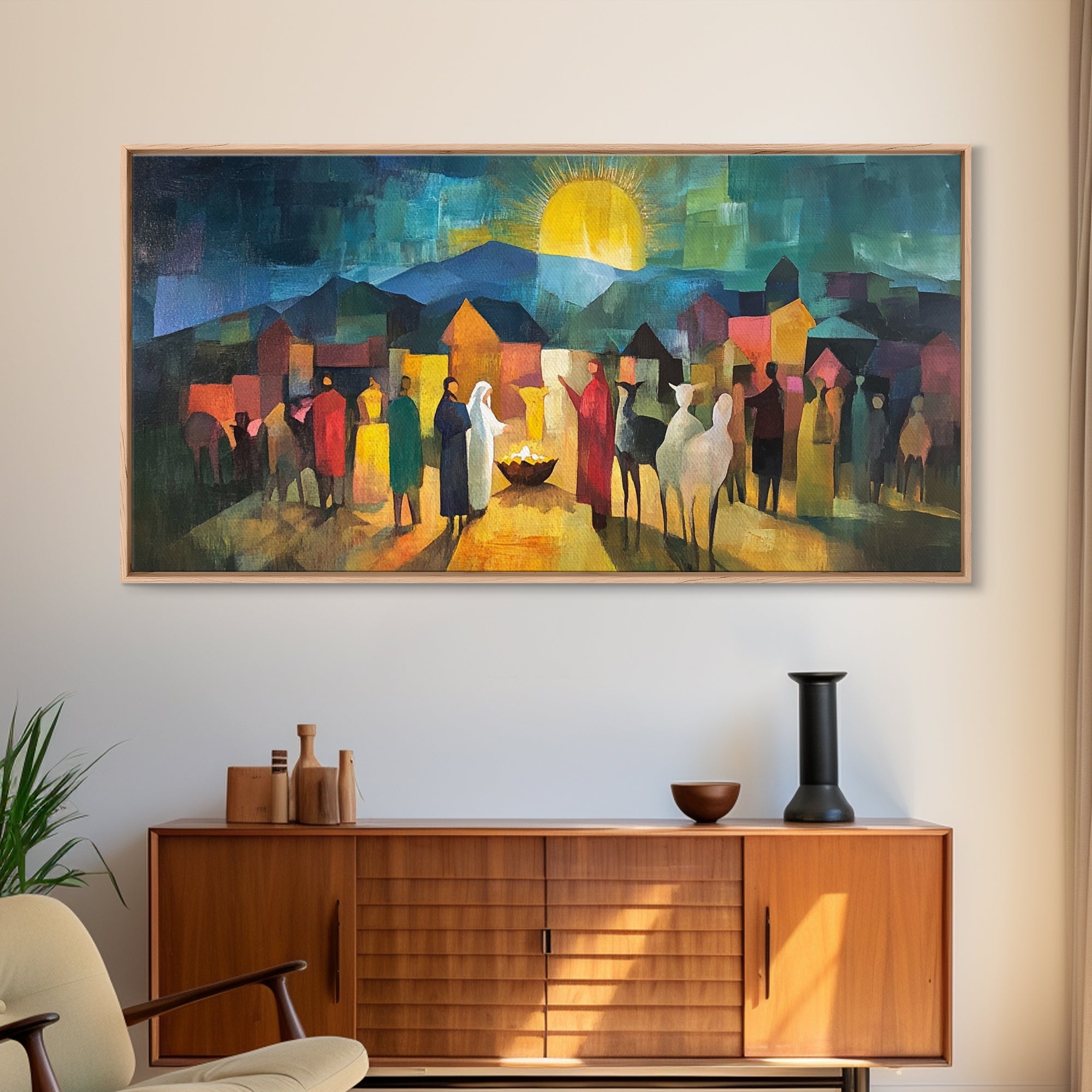 Framed nativity scene art print with standing figures, glowing sky, and houses