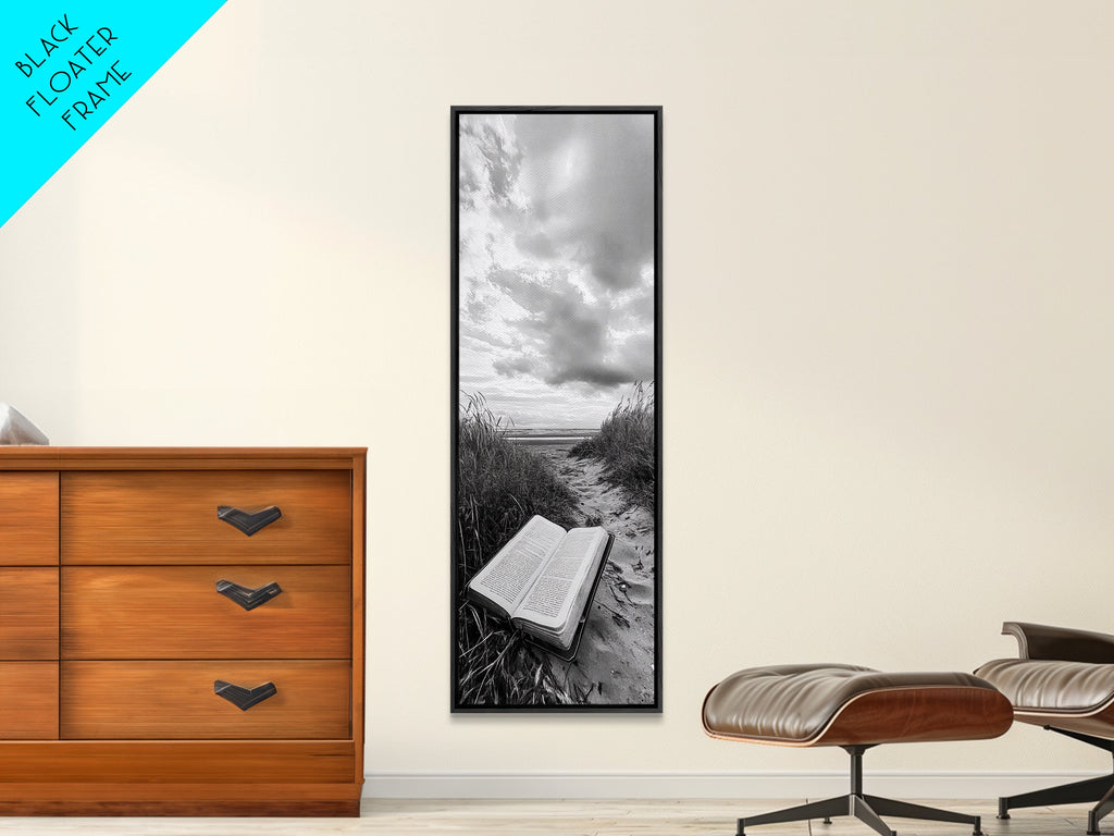Vertical framed canvas print with grayscale open book on beach under cloudy sky