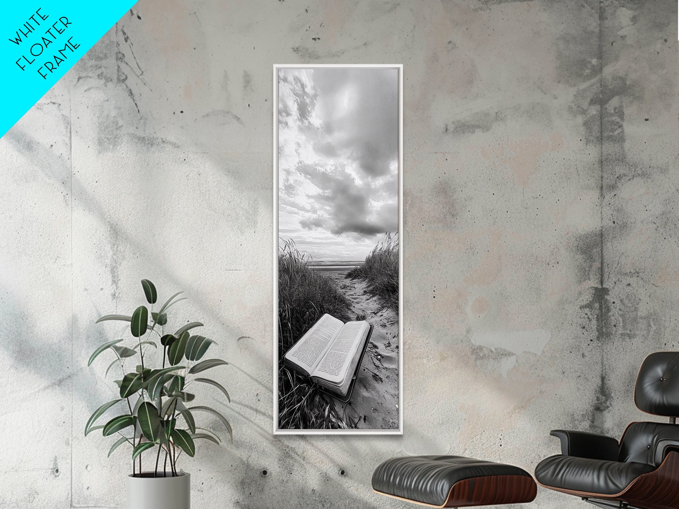 Vertical framed canvas print with grayscale open book on beach, cloudy sky; white frame