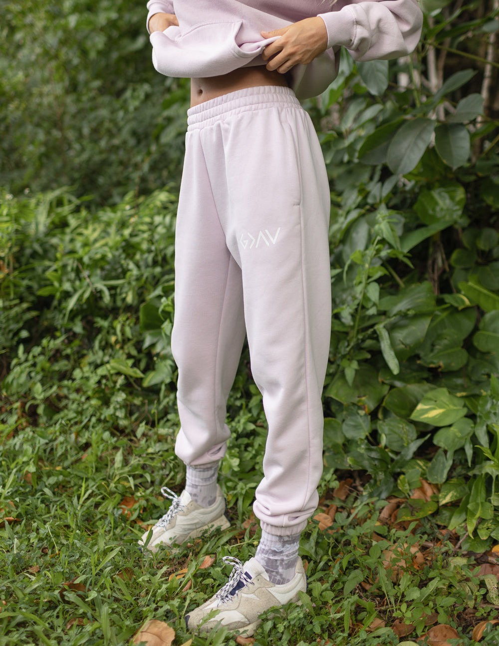 Light purple unisex sweatpants with tapered legs, elastic cuffs, and thigh logo