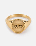 Gold-tone signet ring with engraved mountain-like design on oval face