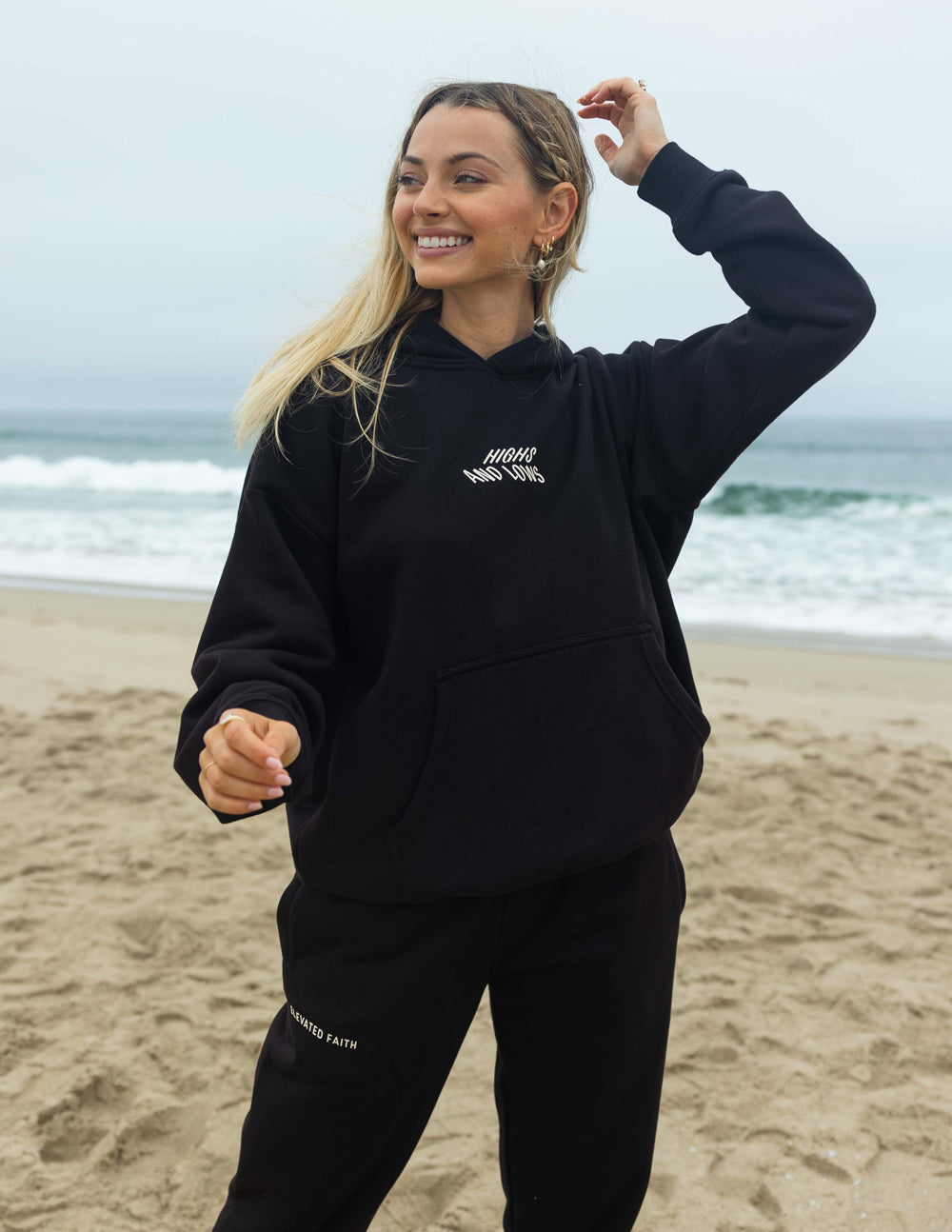 Black unisex pullover hoodie with small chest logo text and kangaroo pocket